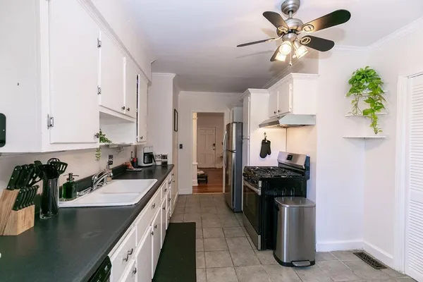 a kitchen with granite countertop a sink counter top space appliances and cabinets