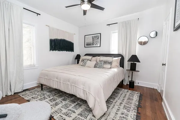 a bedroom with a large bed and a lamp on a dresser