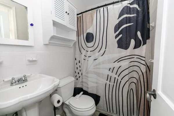 a bathroom with a sink a toilet and a mirror