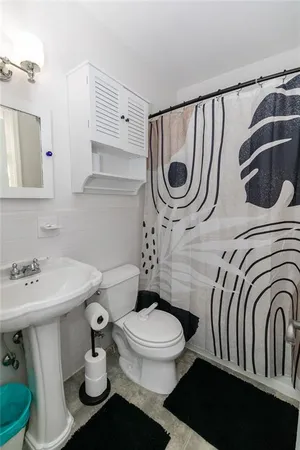 a bathroom with a toilet a sink and mirror