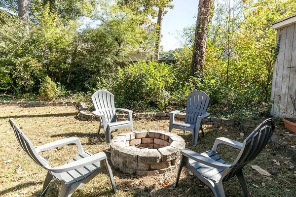 a view of backyard with seating space and trees