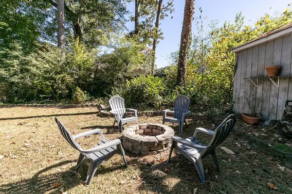 a patio with table and chairs and potted plants