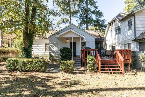 a backyard of a house with large trees and covered with wooden fence
