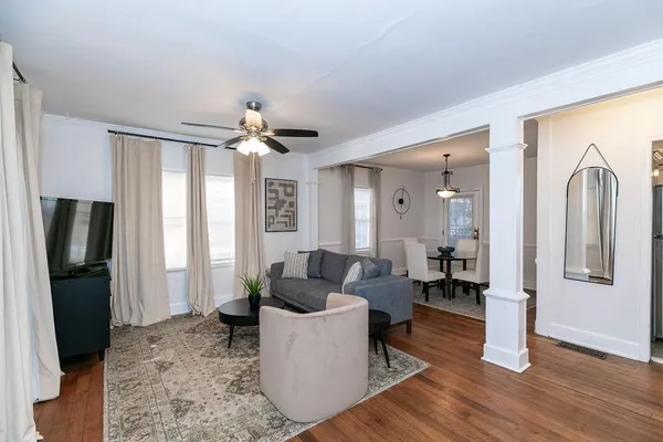 a living room with furniture a flat screen tv and a table