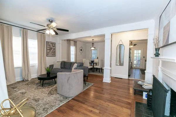 a dining room with furniture potted plants and wooden floor