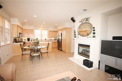 Charming Family Room with surround sound wiring, fireplace with stylish white mantle and elegant tile floors.