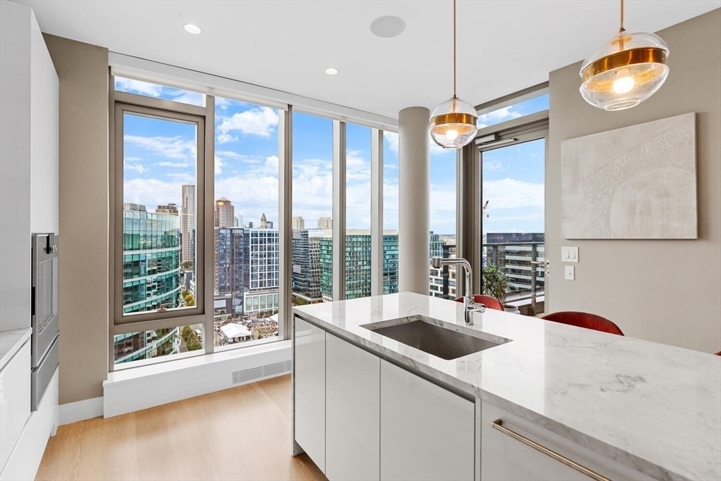 133 Seaport Boulevard, Unit PH 3A Boston, MA 02210 - Photo 11 of 25 a kitchen with a sink a counter top space and stainless steel appliances