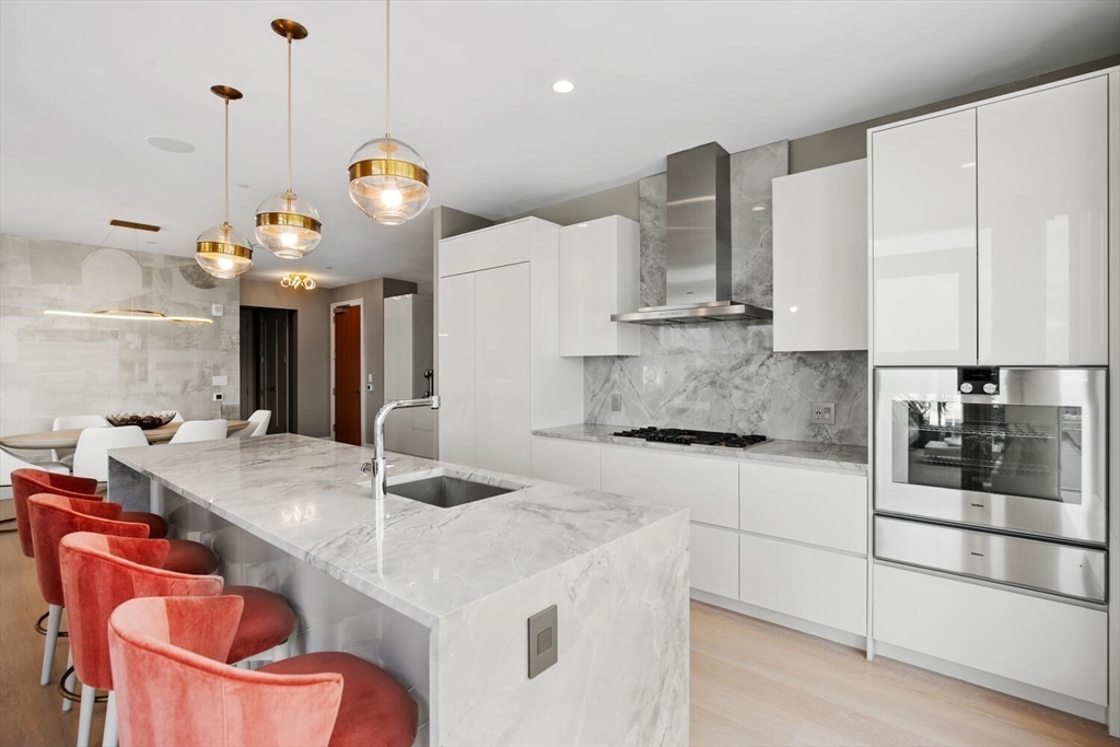 133 Seaport Boulevard, Unit PH 3A Boston, MA 02210 - Photo 13 of 25 a kitchen with stainless steel appliances granite countertop a sink a stove and a refrigerator
