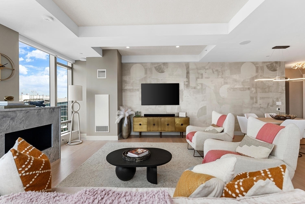 133 Seaport Boulevard, Unit PH 3A Boston, MA 02210 - Photo 15 of 25 a living room with furniture and a flat screen tv