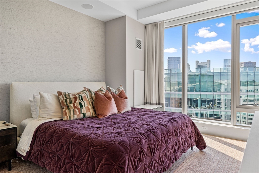 133 Seaport Boulevard, Unit PH 3A Boston, MA 02210 - Photo 16 of 25 a bed sitting in a bedroom next to a large window
