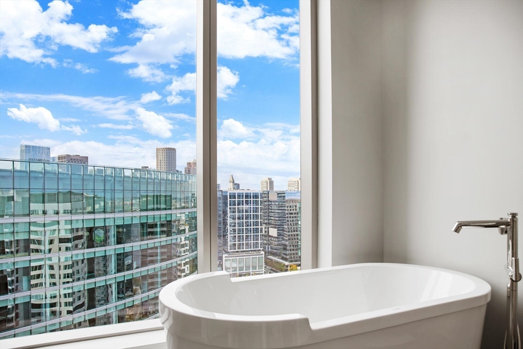 133 Seaport Boulevard, Unit PH 3A Boston, MA 02210 - Photo 17 of 25 a bathroom with a bathtub and window