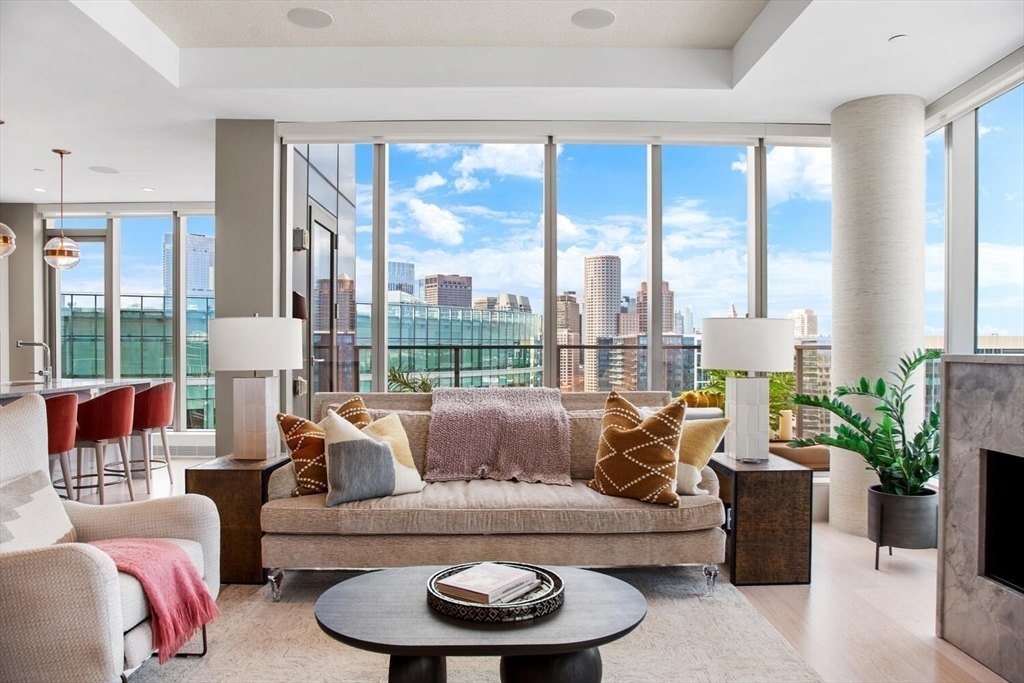 133 Seaport Boulevard, Unit PH 3A Boston, MA 02210 - Photo 2 of 25 a living room with furniture and a large window