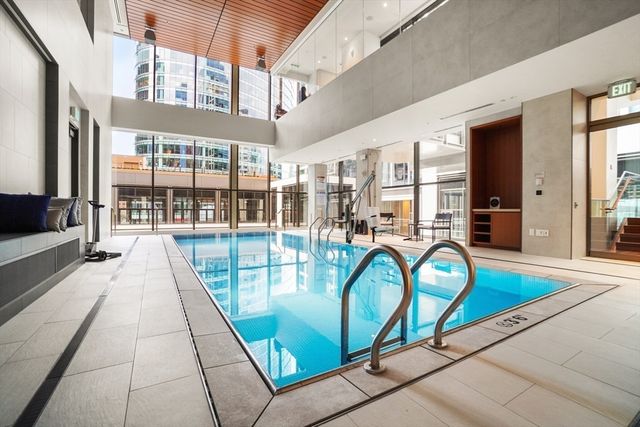 a view of a swimming pool with a couches and dining table