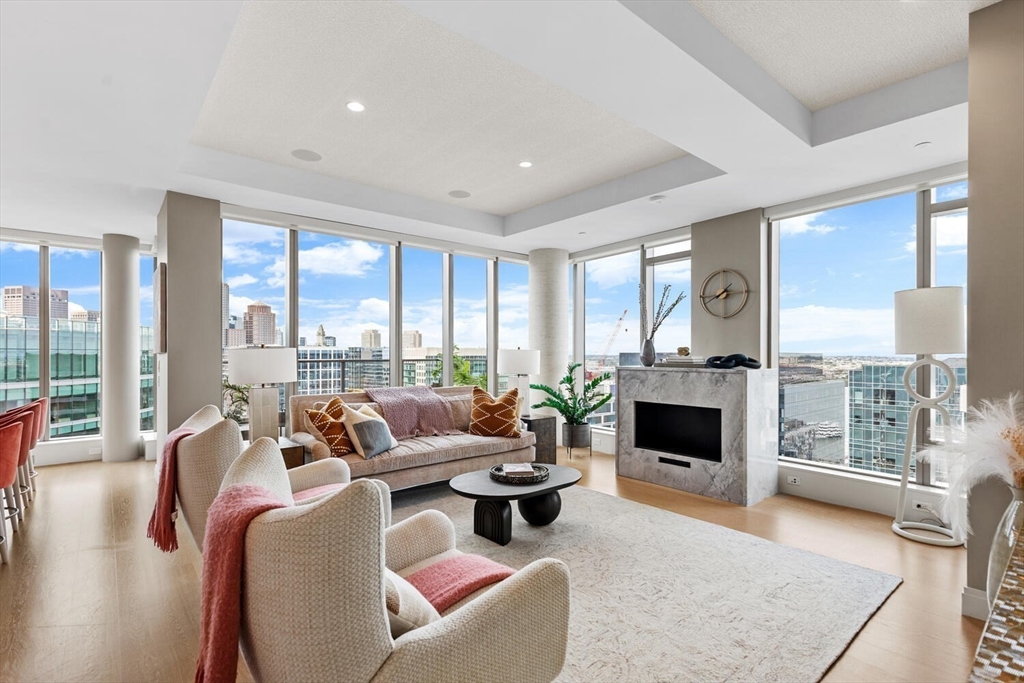 133 Seaport Boulevard, Unit PH 3A Boston, MA 02210 - Photo 5 of 25 a living room with furniture and a fireplace