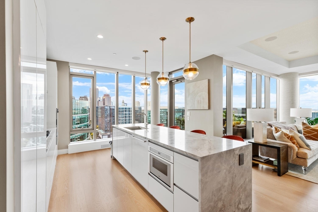 133 Seaport Boulevard, Unit PH 3A Boston, MA 02210 - Photo 6 of 25 a large kitchen with kitchen island a large window in it
