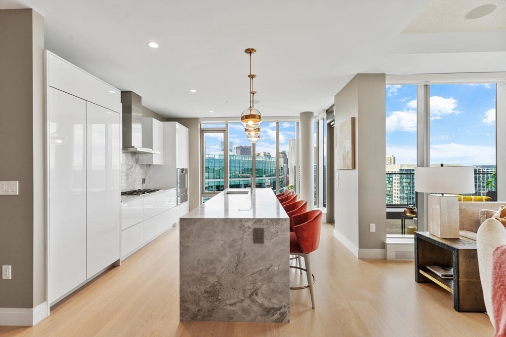 133 Seaport Boulevard, Unit PH 3A Boston, MA 02210 - Photo 8 of 25 a living room with furniture and a large window
