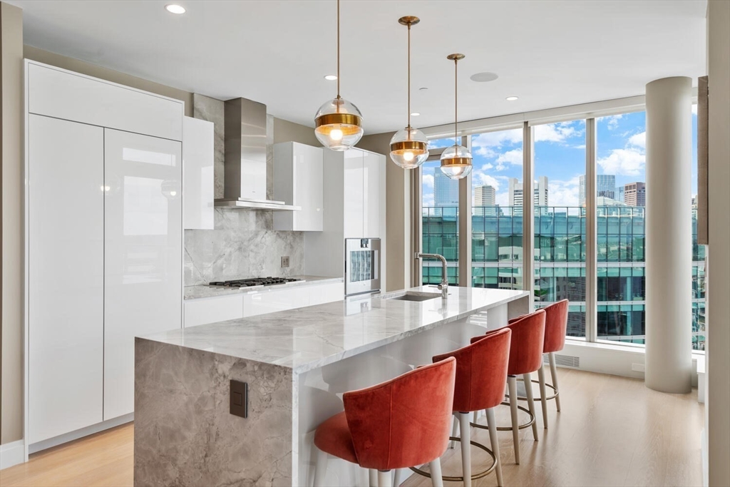 133 Seaport Boulevard, Unit PH 3A Boston, MA 02210 - Photo 10 of 25 a open kitchen with stainless steel appliances granite countertop a stove a sink a refrigerator and a wooden floors