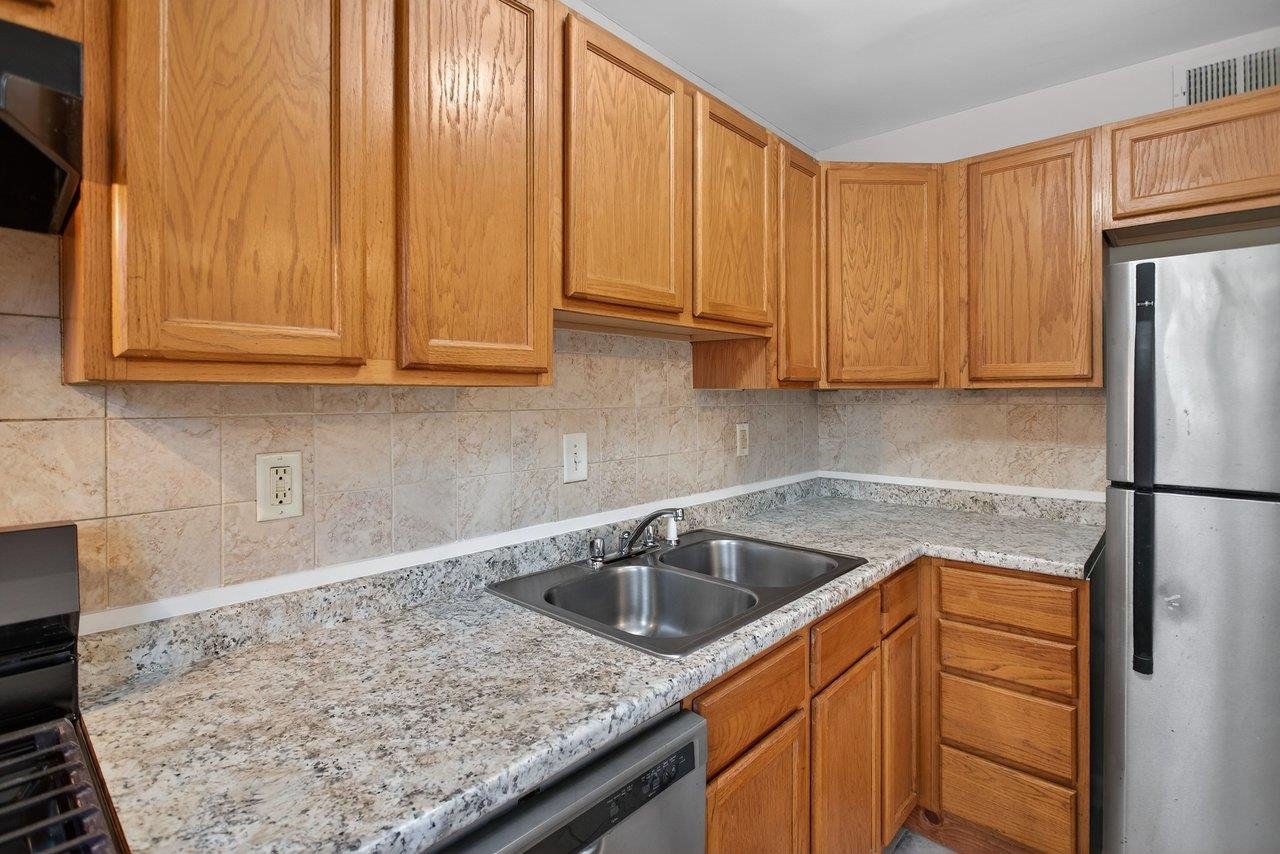 2527 Hydraulic Road, Unit 26 Charlottesville, VA 22901 - Photo 19 of 56 a kitchen with a sink cabinets and a refrigerator