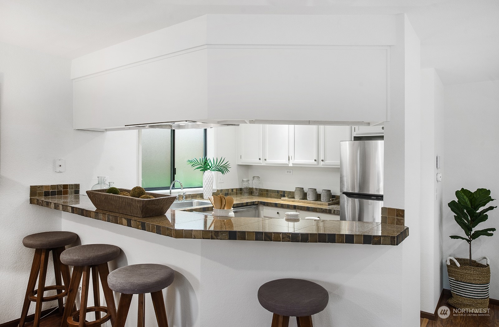 3030 63rd Avenue Southwest, Unit 2 Seattle, WA 98116 - Photo 12 of 32 a kitchen with stainless steel appliances granite countertop a table chairs sink and cabinets