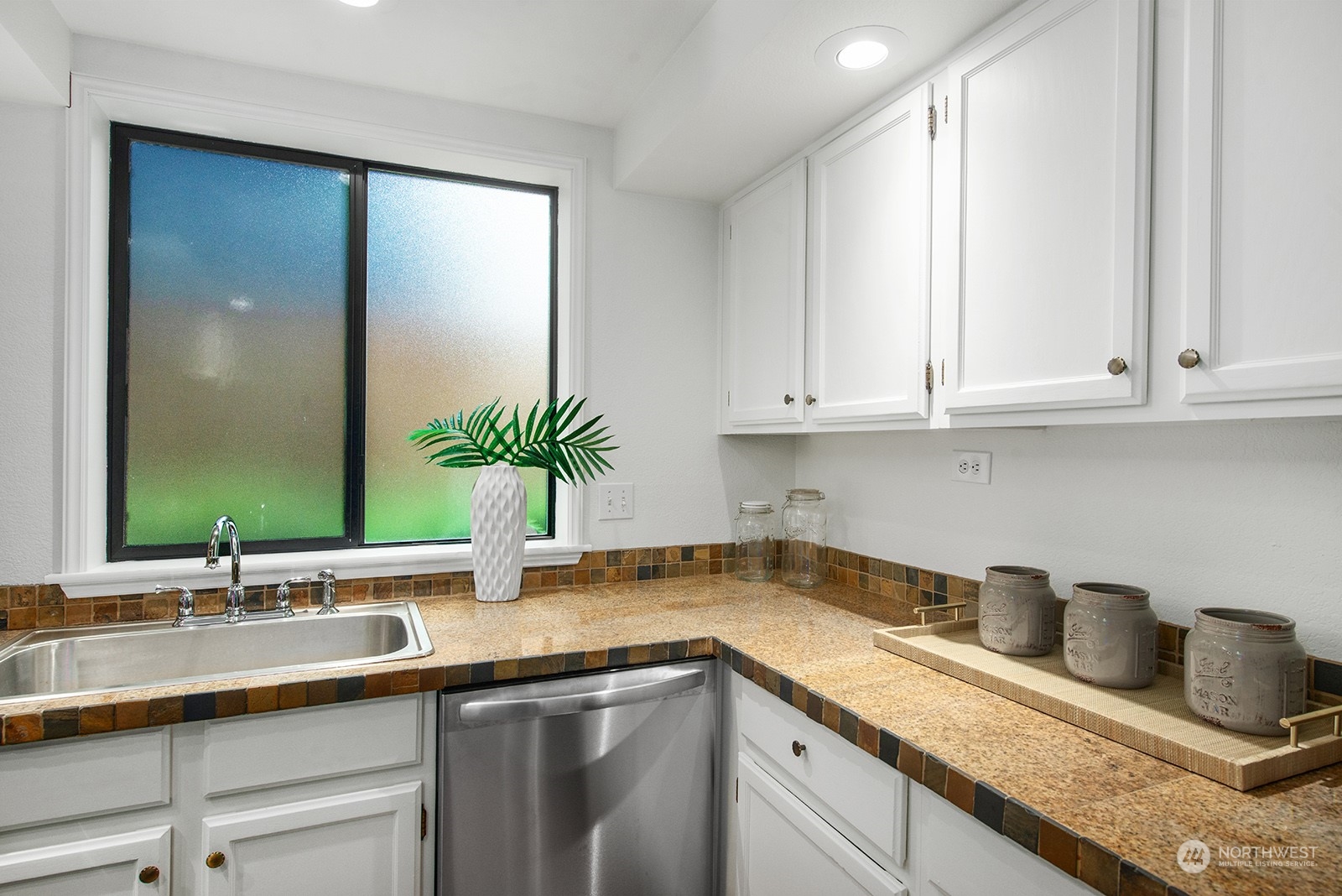 3030 63rd Avenue Southwest, Unit 2 Seattle, WA 98116 - Photo 14 of 32 a kitchen with granite countertop a sink and white cabinets