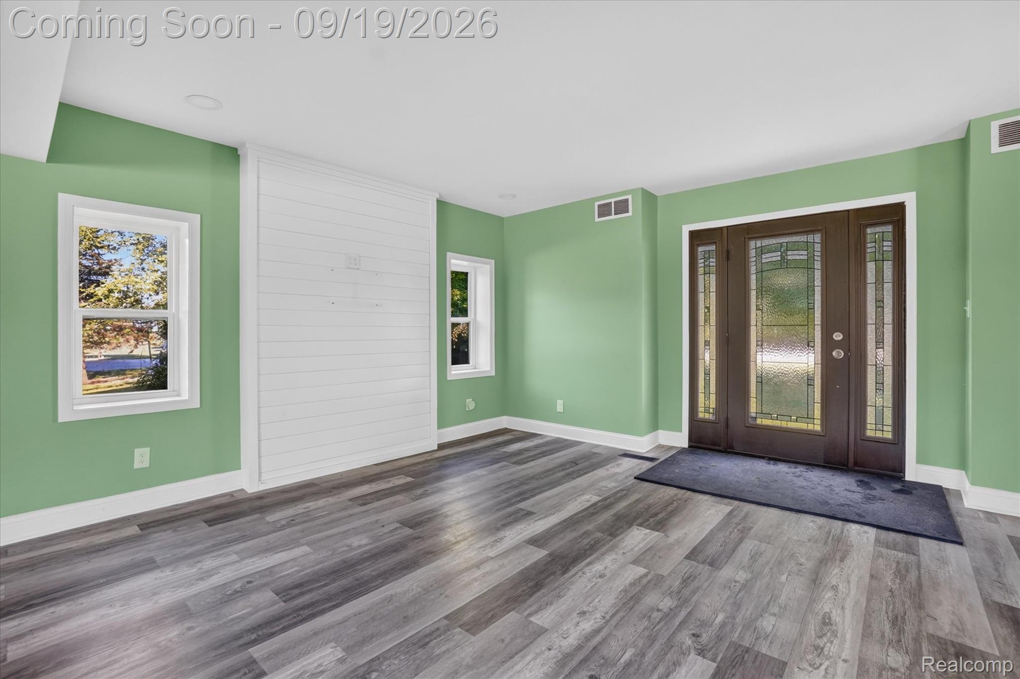 10215 West Mount Morris Road Flushing, MI 48433 - Photo 6 of 58 Wood-finish flooring throughout, a decorative shiplap wall accent, and multiple windows allowing natural illumination