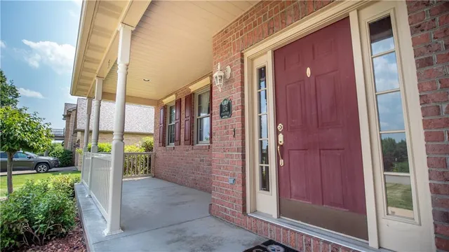 a view of a brick house with a red door and a large window