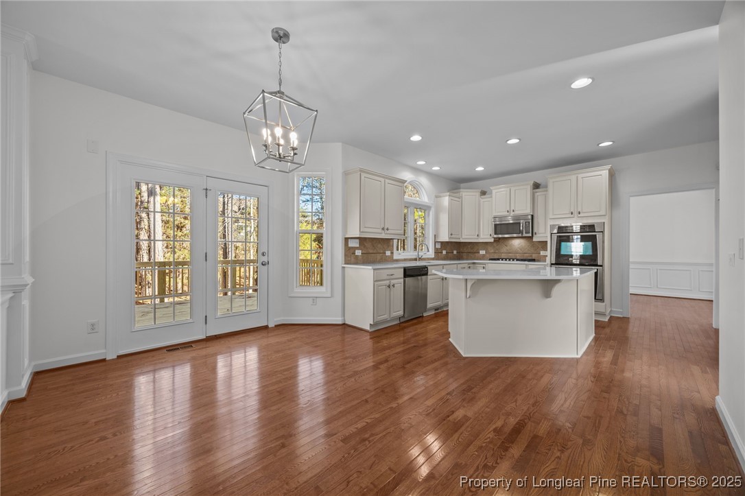 4518 Paces Ferry Drive Durham, NC 27712 - Photo 18 of 44 a view of a kitchen with kitchen island wooden floor wooden floor and center island