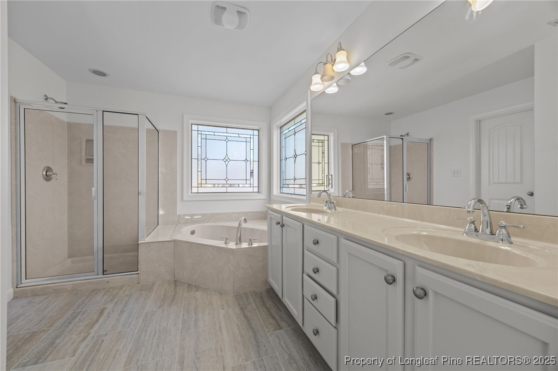 4518 Paces Ferry Drive Durham, NC 27712 - Photo 28 of 44 a spacious bathroom with a granite countertop sink a large mirror and a bathtub