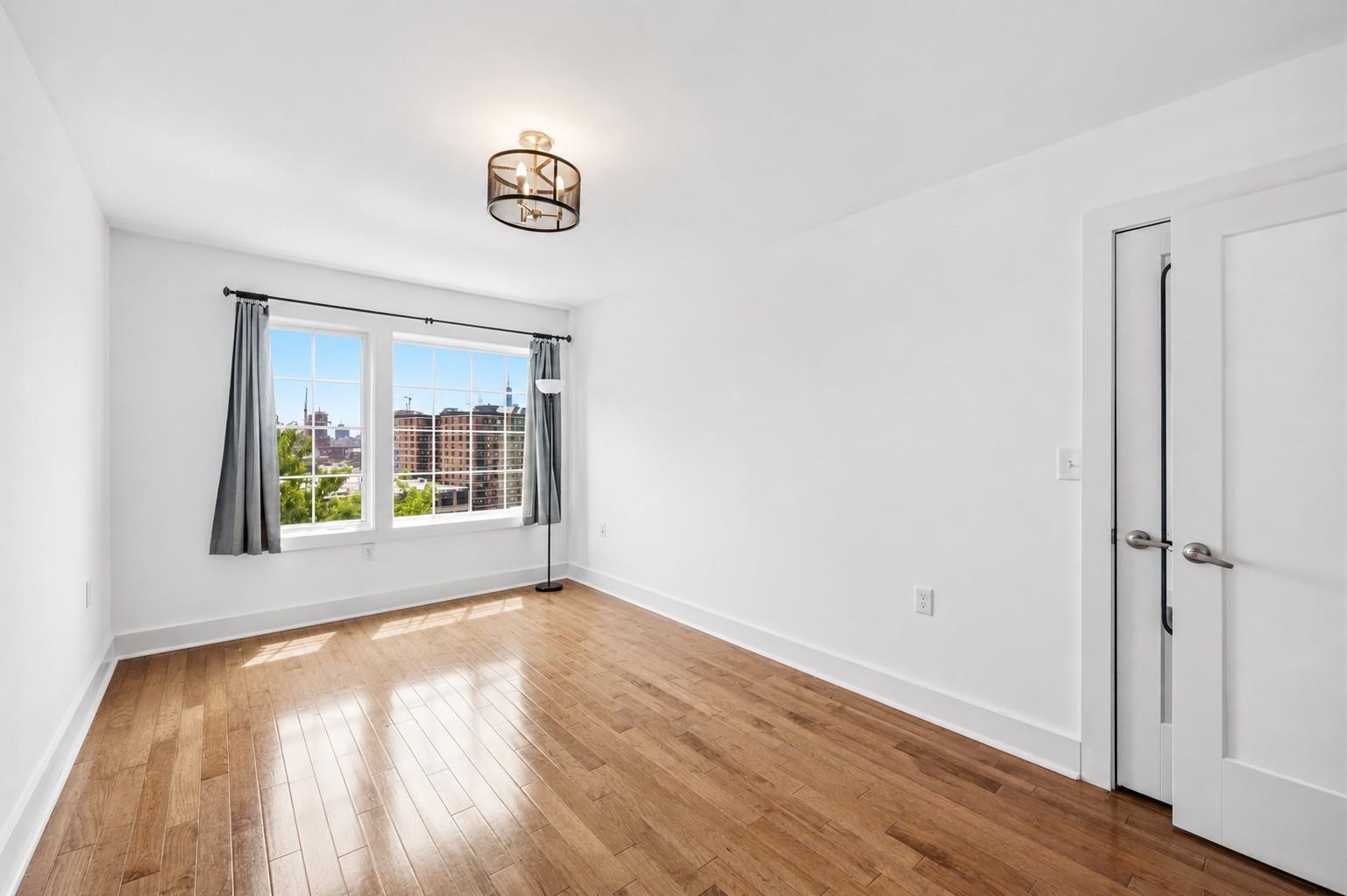 107 Mountain Road Jersey City, NJ 07307 - Photo 22 of 41 a view of an empty room with a window and wooden floor