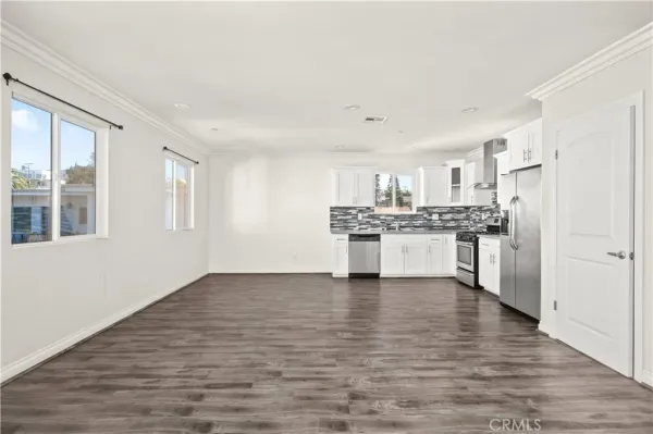 a view of kitchen with granite countertop cabinets and refrigerator