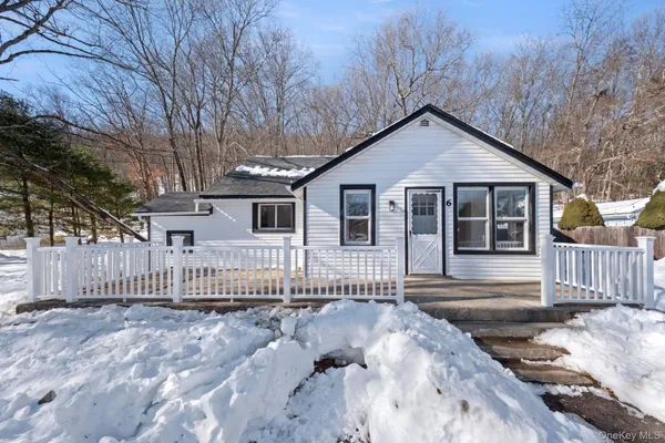 a view of a house with a small yard and wooden fence