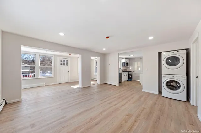a view of empty room with wooden floor and window