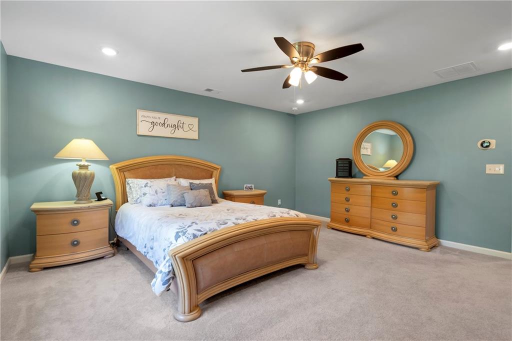 660 Groover Street Ball Ground, GA 30107 - Photo 24 of 53 a bedroom with a bed and a chandelier