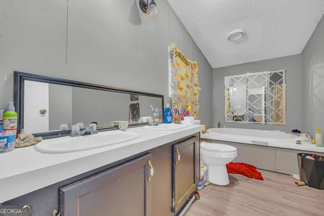 a en suite bathroom with a double vanity sink mirror and a bathtub