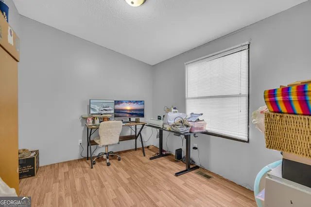 a view of a workspace with furniture and a window