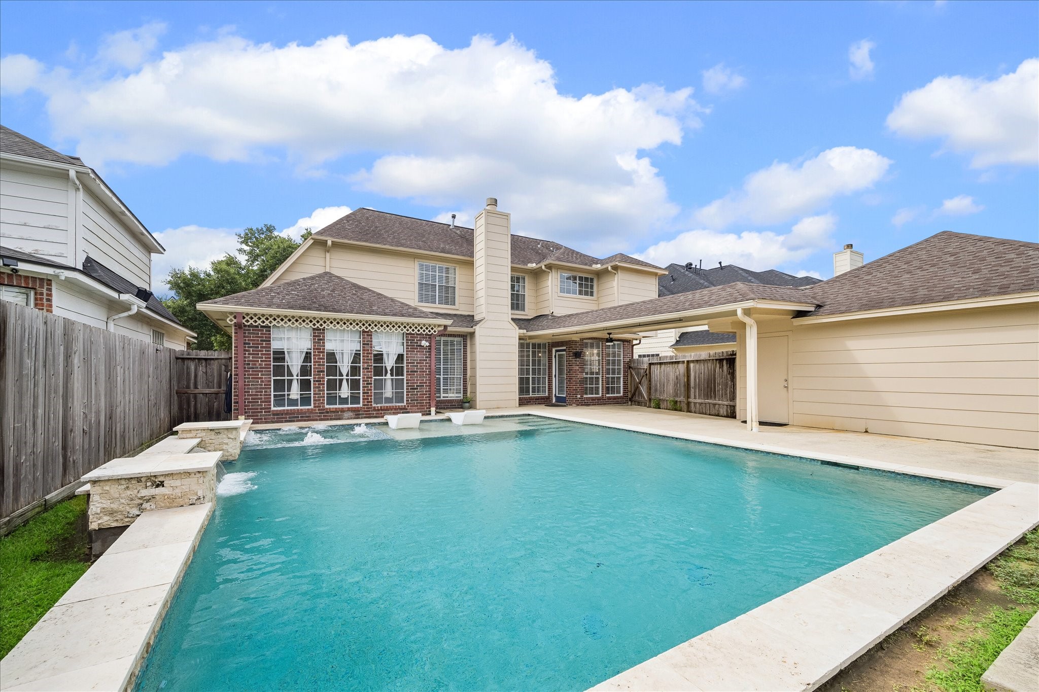 7915 Huddersfield Court Spring, TX 77379 - Photo 37 of 37 Alternate backyard view showing the resort-style pool, sun deck, water features, patio space, and direct connection back to the home.