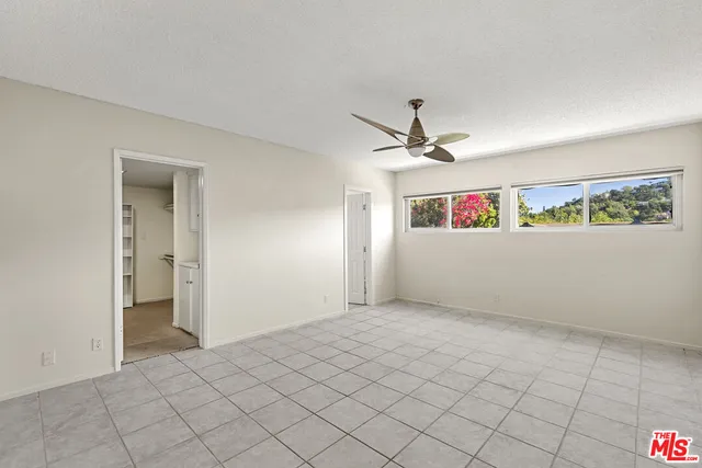 a view of a livingroom with a ceiling fan and window