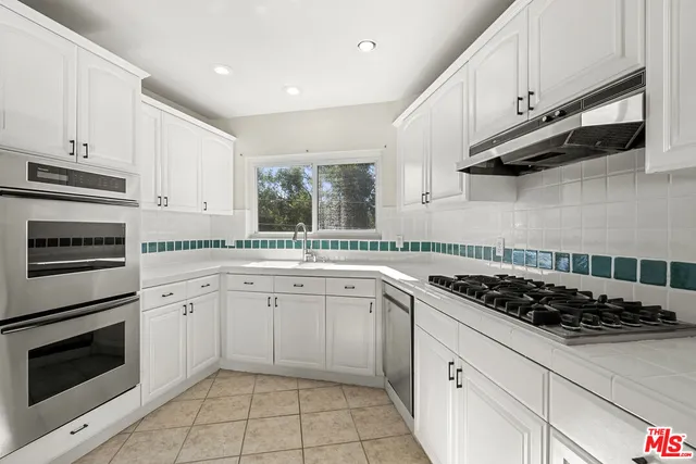 a kitchen with cabinets stainless steel appliances and a sink