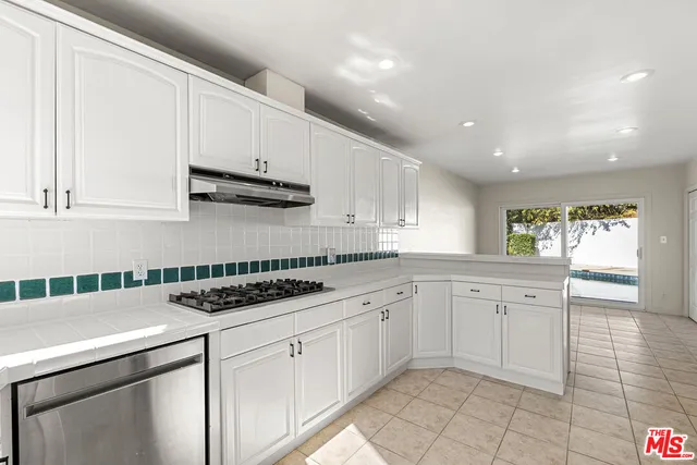 a kitchen with white cabinets a sink and appliances