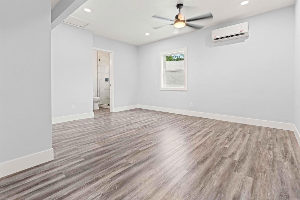 4542 Palm Avenue La Mesa, CA 91941 - Photo 23 of 55 an empty room with wooden floor a ceiling fan white walls and windows