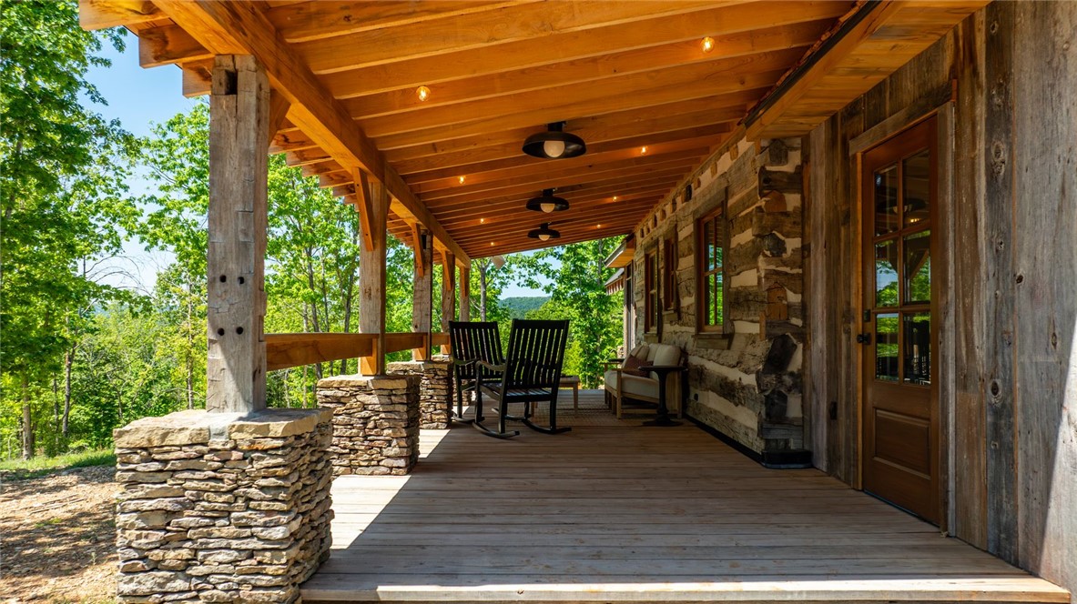 425 Barnhardt Road Timbo, AR 72680 - Photo 56 of 60 Expansive wood-finish deck with stone-stacked pillars, exposed wood beam ceiling, and recessed lighting