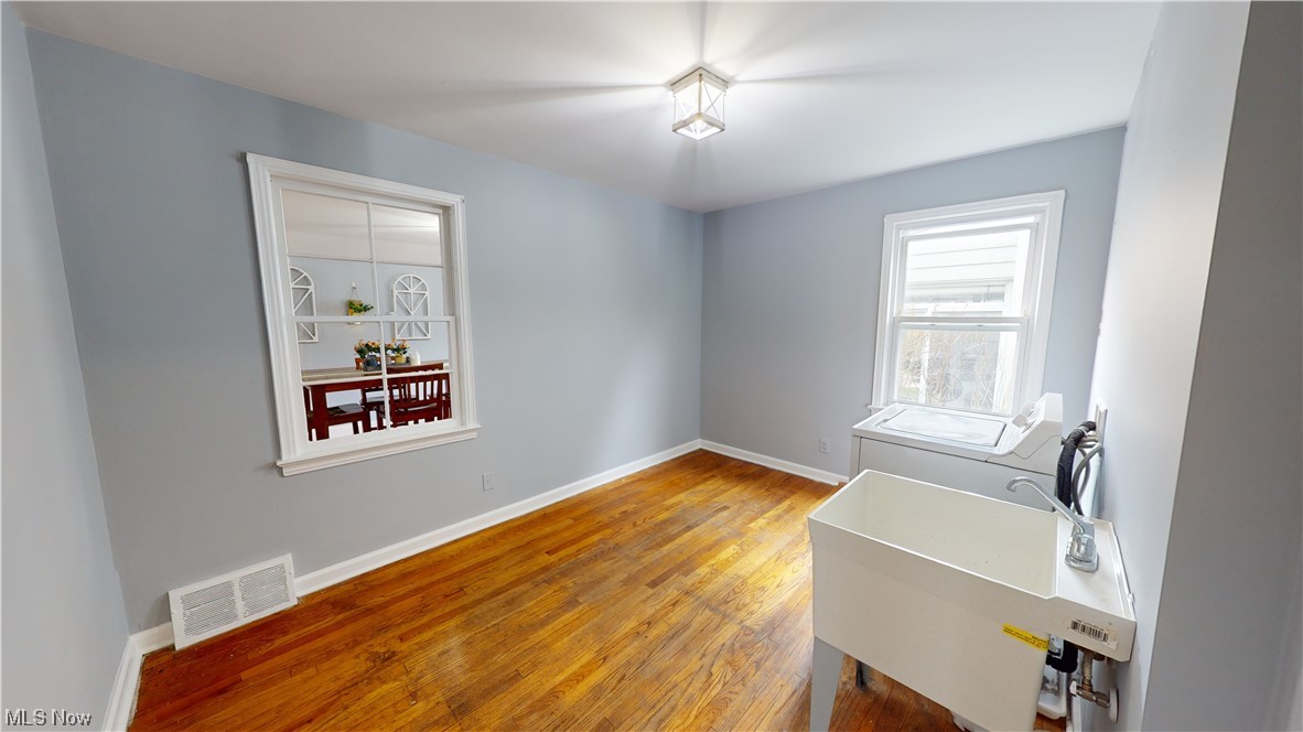 1331 Churchill Road Lyndhurst, OH 44124 - Photo 6 of 35 Spare room featuring washer and clothes dryer, sink, and light hardwood / wood-style flooring