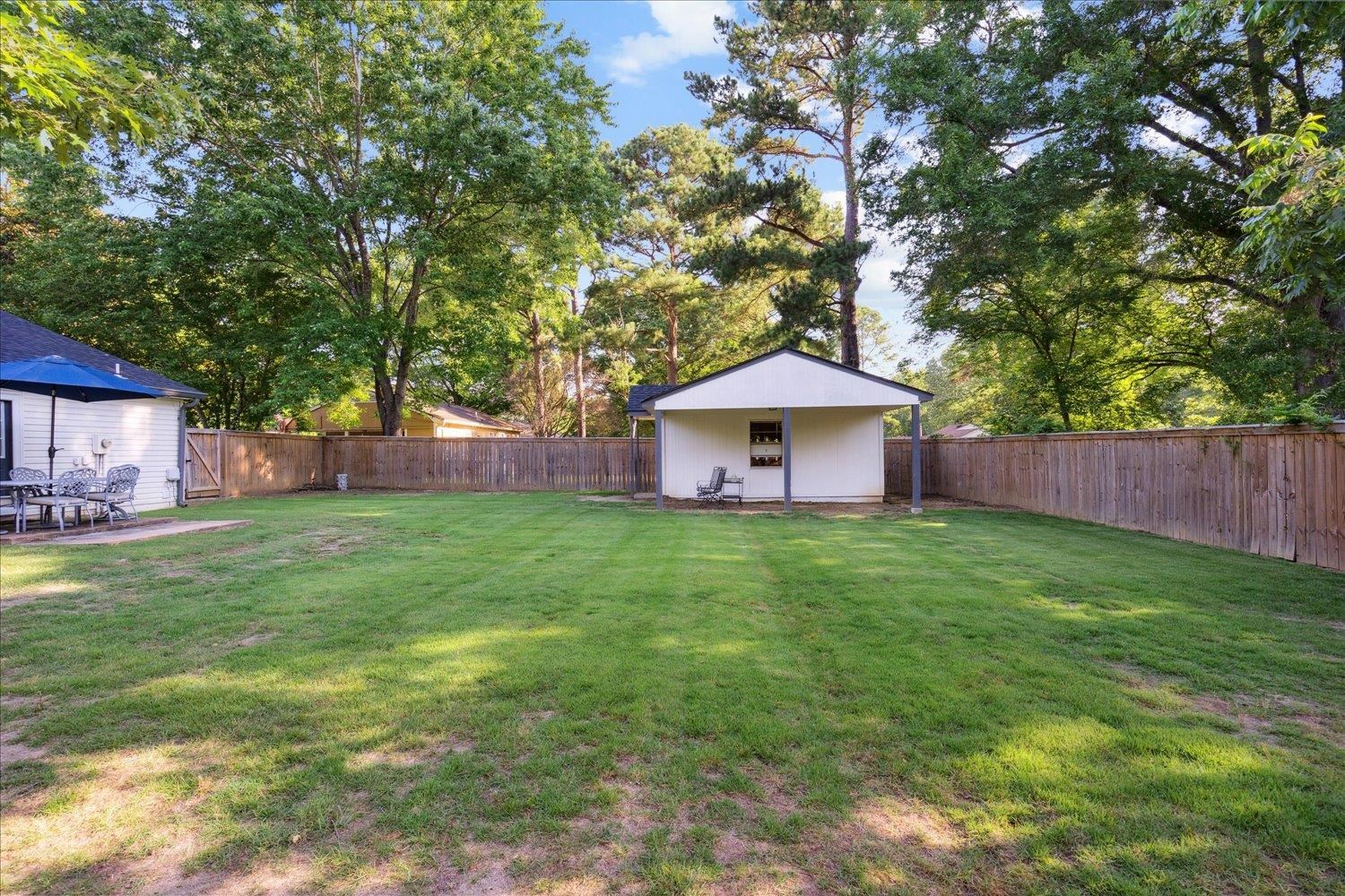 834 Greencliff Road Collierville, TN 38017 - Photo 18 of 20 a backyard of a house with table and chairs plants and large tree
