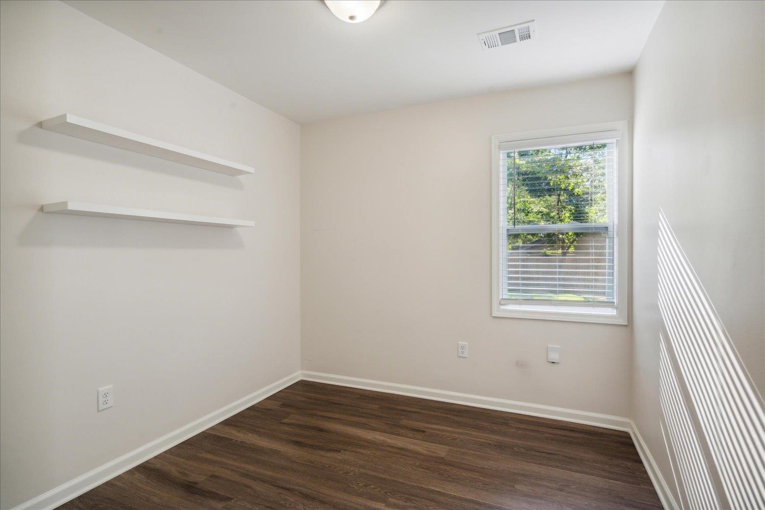 834 Greencliff Road Collierville, TN 38017 - Photo 8 of 20 a view of an empty room with wooden floor and a window