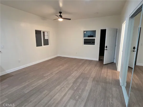 a view of a livingroom with wooden floor and a ceiling fan