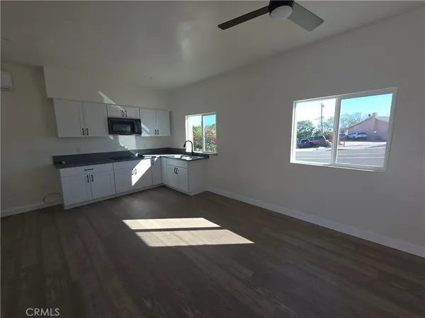 a view of a kitchen with kitchen island stainless steel appliances wooden floor and window