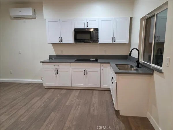 a kitchen with granite countertop a stove and a wooden floor