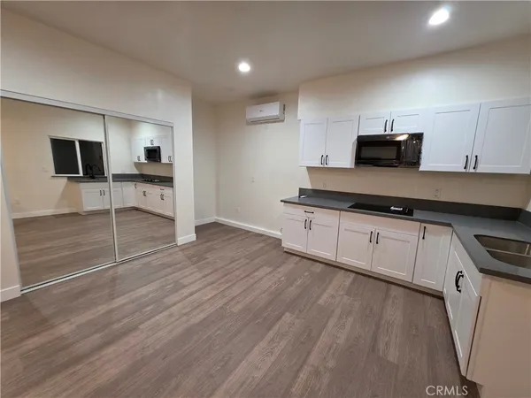 a kitchen with granite countertop a stove and cabinets