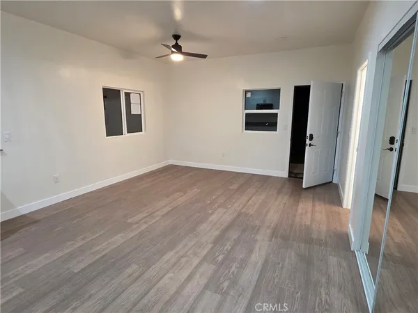 a view of a livingroom with wooden floor and a ceiling fan