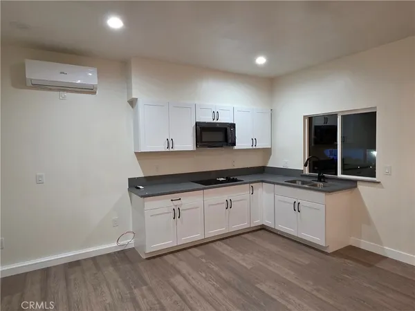 a kitchen with granite countertop a sink and a stove top oven